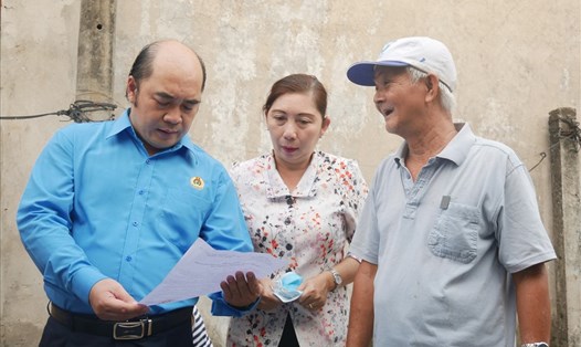 Ông Hồ Xuân Lâm - Phó Chủ tịch LĐLĐ TPHCM (trái ảnh) phổ biến các thông tin phòng chống dịch bệnh COVID-19 đến chủ nhà trọ. Ảnh: Anh Tú