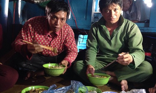 Hình ảnh ngư dân Nguyễn Tèo (áo đỏ) và bạn thuyền ăn bát bún đầu tiên sau nhiều ngày chống chọi với vụ chìm tàu. Ảnh: P.Linh