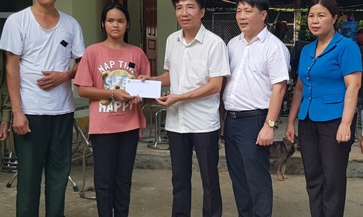 Đại diện Qũy XHTT Tấm lòng Vàng Lao Động trao tiền hỗ trợ cho gia đình chị Quách Thị Thắm. Ảnh: NT