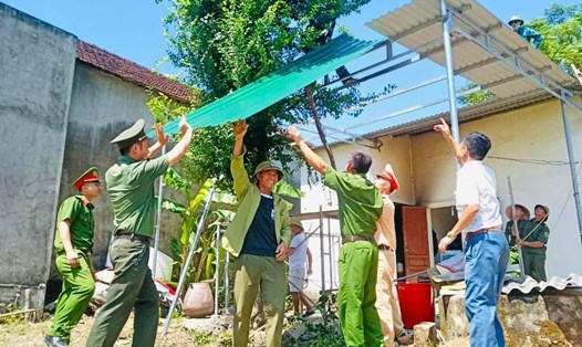Cán bộ, chiến sĩ công an huyện Đô Lương tiến hành hỗ trợ xây dựng công trình mái che cho gia đình Mẹ Nguyễn Thị Loan. Ảnh: CĐ CA tỉnh Nghệ An.
