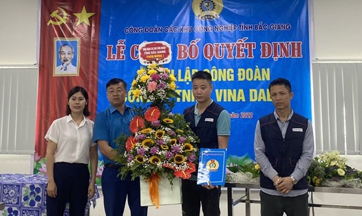 Ông Ngô Đức Thắng, Chủ tịch Công đoàn Các khu công nghiệp tỉnh (thứ 2 từ trái qua) trao quyết định và tặng hoa chúc mừng Công đoàn cơ sở công ty.