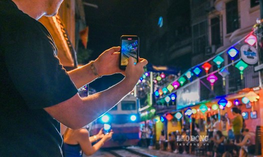 Khách du lịch thích thú check-in tại phố đường tàu (Hà Nội) mỗi khi có tàu chạy qua.