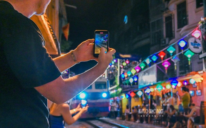 Khách du lịch thích thú check-in tại phố đường tàu (Hà Nội) mỗi khi có tàu chạy qua.