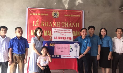 Ông Nguyễn Văn Bắc - Phó Chủ tịch Thường trực Liên đoàn Lao động tỉnh Bắc Giang (thứ tư từ phải qua) trao hỗ trợ kinh phí và quà cho gia đình đoàn viên Thủy.
