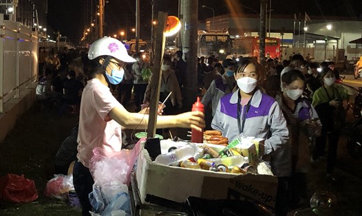 Nữ công nhân làm việc tại Khu công nghiệp Quang Châu (huyện Việt Yên, tỉnh Bắc Giang) mua đồ ăn trước khi vào ca. Ảnh: Bảo Hân