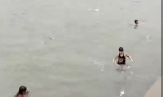 Nhóm trẻ em tắm biển bất chấp nguy hiểm của ngày mưa bão. Ảnh cắt từ video clip