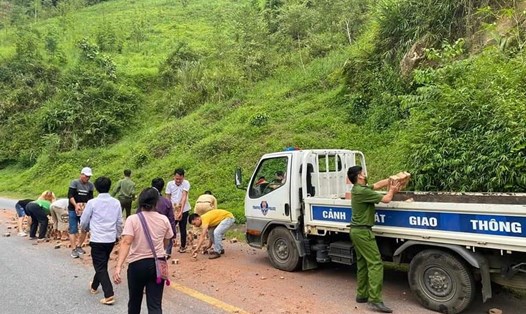 Lực lượng cảnh sát giao thông huyện Văn Chấn cùng bà con nhặt gạch rơi vãi để đảm bảo an toàn giao thông. Ảnh: CTV.