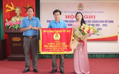 Chủ tịch LĐLĐ Quảng Bình Phạm Tiến Nam trao tặng cờ thi đua xuất sắc của Tổng LĐLĐ Việt Nam cho Công đoàn ngành Giáo dục Quảng Bình. Ảnh: LPL