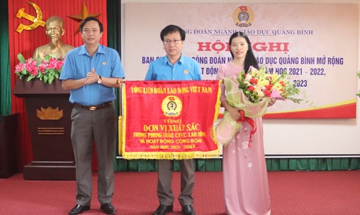 Chủ tịch LĐLĐ Quảng Bình Phạm Tiến Nam trao tặng cờ thi đua xuất sắc của Tổng LĐLĐ Việt Nam cho Công đoàn ngành Giáo dục Quảng Bình. Ảnh: LPL