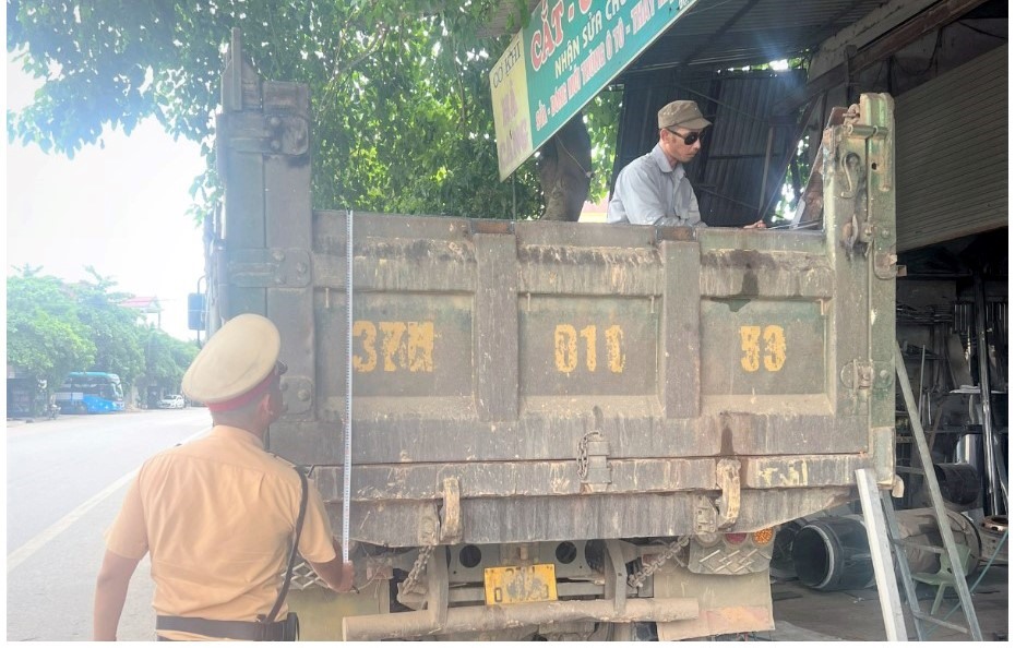 CSGT Nghệ An vận động doanh nghiệp tự giác cắt bỏ phần cơi nới của thành, thùng xe. Ảnh: Bình Minh