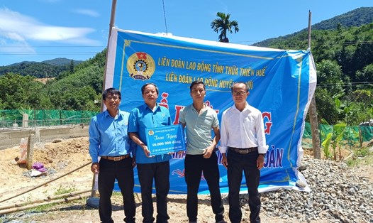 Ông Trần Duy Nguyên (trái) - Chủ tịch LĐLĐ huyện A Lưới trao hỗ trợ nhà "Mái ấm Công đoàn" cho đoàn viên Hồ Văn Nguyên. Ảnh: N. Phương.