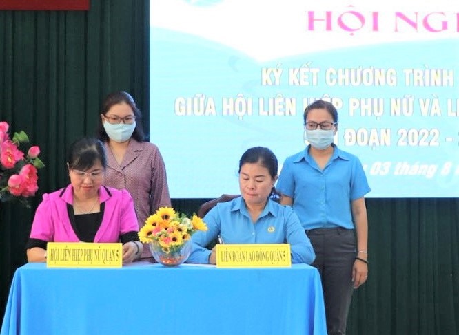 Đại diện LĐLĐ và Hội Liên hiệp Phụ nữ Quận 5 ký kết chương trình phối hợp. Ảnh: Đức Long