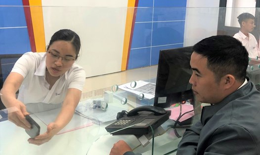 Nhân viên PC Đắk Nông hướng dẫn khách hàng các dịch vụ về điện. Ảnh: Tâm An