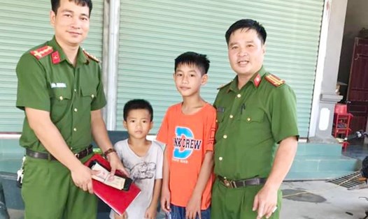 Công an xã Thanh Bình Thịnh tiếp nhận chiếc ví chứa hơn 14 triệu đồng từ các em học sinh nhặt được. Ảnh: CA.