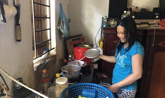 Chị Tạ Thị Hiền chuẩn bị bữa ăn trưa cho 2 mẹ con. Ảnh: Bảo Hân