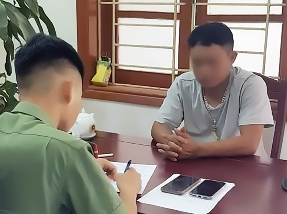 Cán bộ công an huyện Đô Lương làm việc với chủ tài khoản facebook “Lê Văn Lâm” sinh năm 1982, trú tại xóm Yên Thế, xã Thịnh Sơn, huyện Đô Lương, tỉnh Nghệ An. Ảnh: CANA