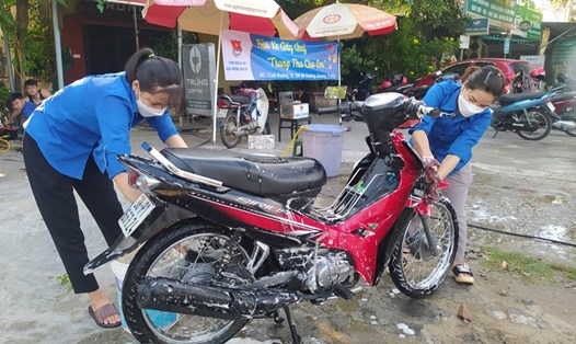 Nhóm đoàn viên thanh niên phường Thạch Quý rửa xe gây quỹ mua quà Trung thu tặng trẻ em nghèo. Ảnh: TT.
