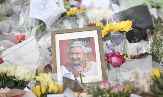 Bức chân dung của Nữ hoàng Anh Elizabeth II giữa những bông hoa bên ngoài Cung điện Buckingham ở London, ngày 10.9.2022. Ảnh: AFP