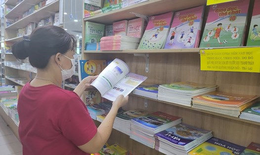 Phụ huynh tìm mua sách giáo khoa mới cho con. Ảnh: Huyên Nguyễn