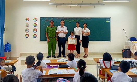 Lãnh đạo UBND thị trấn Đầm Hà trao giấy khen cho em Hoàng Thị Thu Minh. Ảnh: CTV