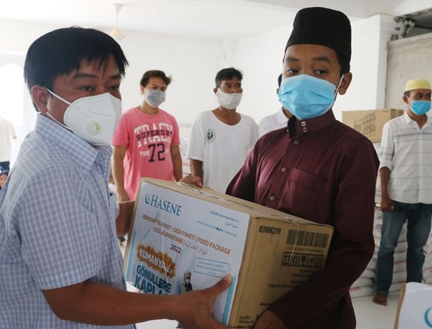 Ông Nguyễn Ngọc Huynh, Bí thư Đảng ủy, Chủ tịch UBND xã Đa Phước, huyện An Phú (An Giang) tặng quà cho đồng bào người Chăm có hoàn cảnh khó khăn. Ảnh: TTXVN