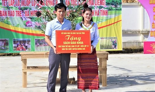 Đại diện Sở GD&ĐT Hà Tĩnh trao tặng SGK cho học sinh dân tộc Chứt tại bản Rào Tre (xã Hương Liên - Hương Khê). Ảnh: La Giang