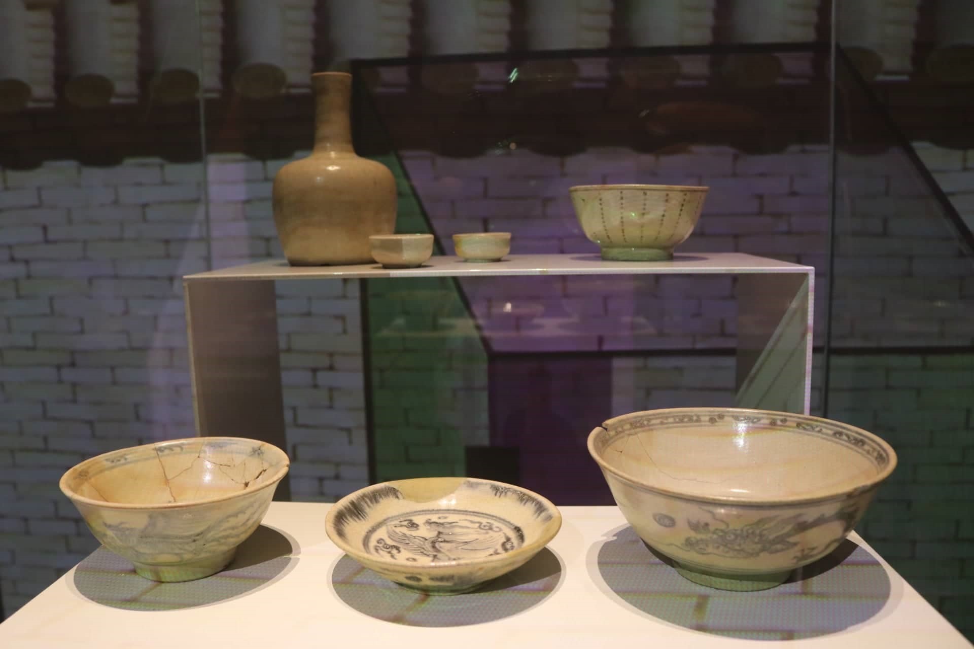 Nậm và chén rượu nhỏ men trắng thời Lê Trung hưng (hàng trên, thế kỷ XVII-XVIII) và bát nhỏ hoa lam thời nhà Mạc (hàng dưới, thế kỷ XVI).