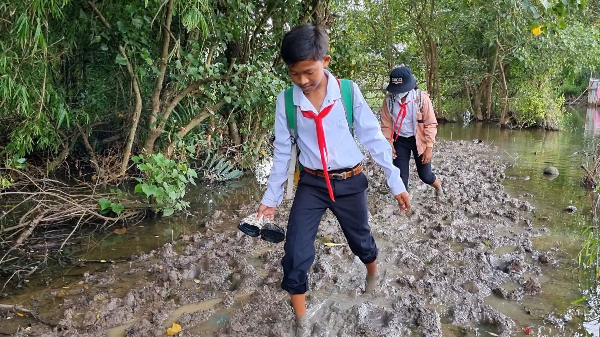 Em Triệu Minh Thạch cùng bạn lội sình đi học mỗi ngày. Ảnh: Văn Sỹ