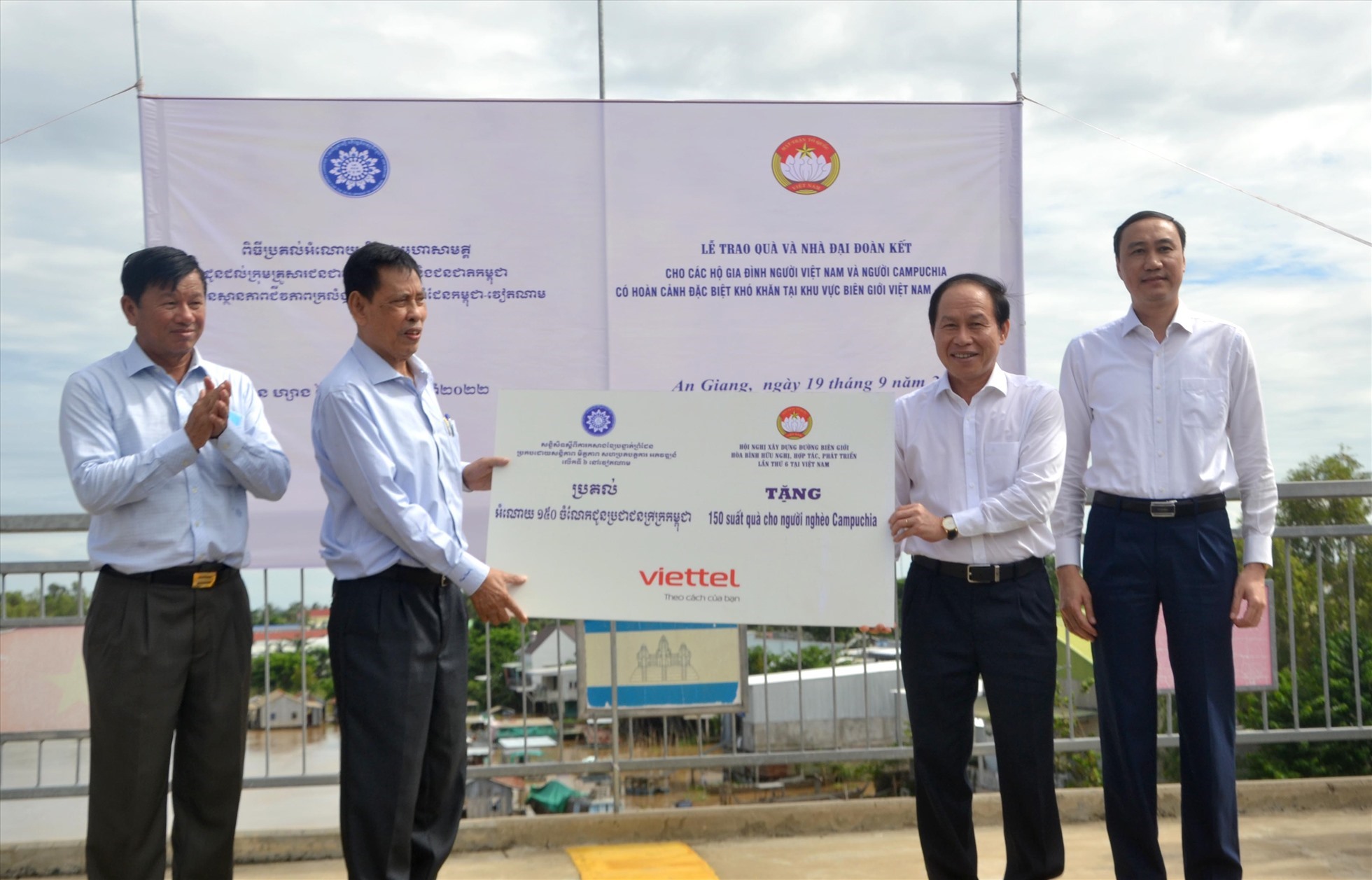 Ông Lê Tiến Châu (thứ 2 từ phải sang) trao biển tượng trưng 150 phần quà cho hộ Campuchia có hoàn cảnh đặc biệt khó khăn.  Ảnh: LT