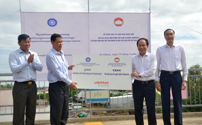 Ông Lê Tiến Châu (thứ 2 từ phải sang) trao biển tượng trưng 150 phần quà cho hộ Campuchia có hoàn cảnh đặc biệt khó khăn.  Ảnh: LT