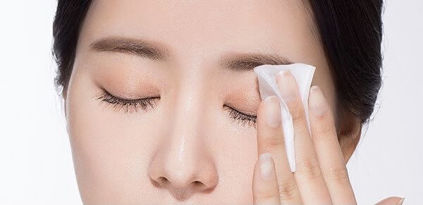 Một trong những mẹo tẩy trang là nhẹ nhàng dùng bông đã thấm nước tẩy trang rồi đặt lên mắt. Ảnh: ST
