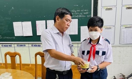 Thầy Lâm Ngọc Thành, Chủ tịch CĐCS trao đến học sinh của trường suất ăn sáng. Ảnh: Cẩm Tú