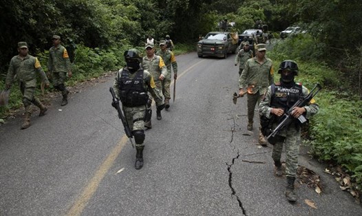 Binh sĩ đi trên con đường bị hư hại một ngày sau trận động đất  7,6 độ richter gần Chinicuila, bang Michoacan, Mexico. Ảnh: Armando Solis