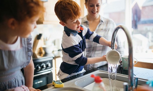 Cha mẹ nên dạy trẻ làm việc nhà để giúp con học cách tự lập. Ảnh: Xinhua