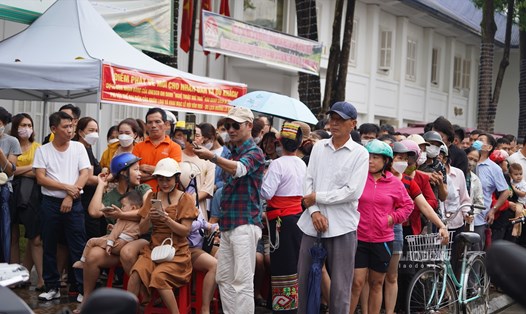 Người dân xếp hàng dài chờ đến lượt nhận vé miễn phí vào cửa để tham dự Lễ vinh danh Nghệ thuật Xòe Thái từ Ban Tổ chức. Ảnh: PV.