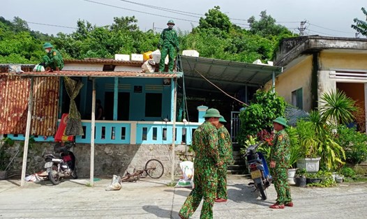 Dân quân giúp chằng chống nhà cửa cho dân ở đảo Cù Lao Chàm sáng 26.9. Ảnh: NTH