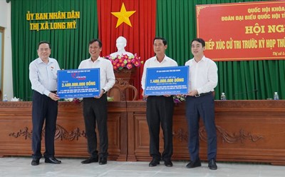 Phó Chủ tịch Thường trực Quốc hội Trần Thanh Mẫn (ngoài cùng bên trái) cùng lãnh đạo tỉnh Hậu Giang trao biển tượng trưng tài trợ làm đường.