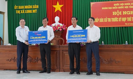 Phó Chủ tịch Thường trực Quốc hội Trần Thanh Mẫn (ngoài cùng bên trái) cùng lãnh đạo tỉnh Hậu Giang trao biển tượng trưng tài trợ làm đường.