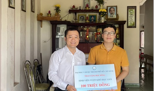 Ông Trương Văn Đạt - Trưởng phòng Công tác Sinh viên Trường Đại học Y Dược TPHCM (bên trái) - trao học bổng hỗ trợ tân sinh viên Lê Văn Hữu. Ảnh: NTCC