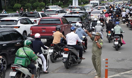 Điều tiết, hướng dẫn người dân lưu thông hướng thay thế sau khi cấm xe qua cầu vượt Nguyễn Hữu Cảnh. Ảnh: M.Q
