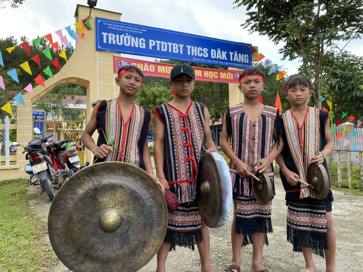 Các em học sinh mang chiêng đi khai giảng năm học mới. Ảnh: T.Tuấn
