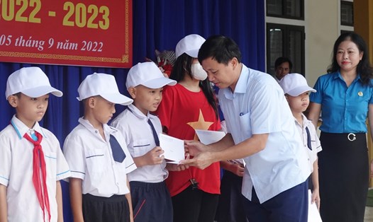 Ông Nguyễn Văn Danh - Chủ tịch LĐLĐ Hà Tĩnh tặng 10 suất học bổng cho học sinh Trường Tiểu học và THCS Đậu Liêu. Ảnh: Trần Tuấn.