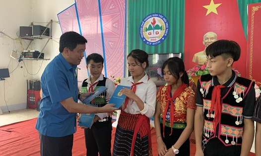Chủ tịch LĐLĐ tỉnh Nghệ An Kha Văn Tám tặng quà cho học sinh Trường Phổ thông dân tộc nội trú THCS huyện Kỳ Sơn trong Lễ khai giảng. Ảnh: TT