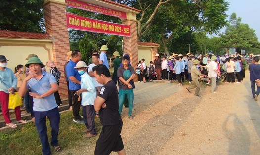 Hàng trăm người dân xã Lạng Sơn tập trung trước cổng trường THCS Khai Lạng để phản đối việc sáp nhập trường gây khó khăn cho việc đi lại của con em. Ảnh: QĐ