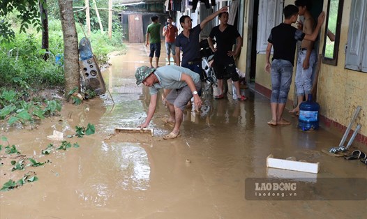 Công nhân Hòa Bình oằn mình dọn dẹp hậu quả sau mưa lũ. Ảnh: Hùng Dân