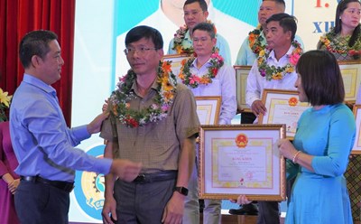 Ông Huỳnh Sơn Tuấn - Chủ tịch LĐLĐ tỉnh trao vòng hoa cho anh Hoàng Minh An - một tấm gương điển hình trong phong trào Lao động giỏi - lao động sáng tạo. Ảnh: T.A