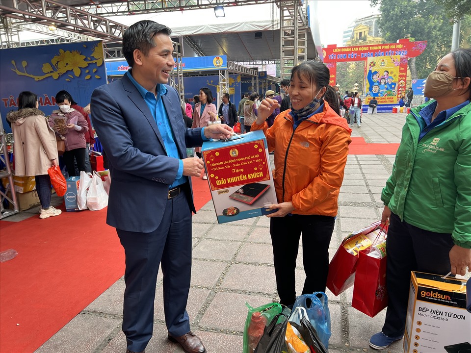Phó Chủ tịch Liên đoàn Lao động Thành phố Hà Nội Lê Đình Hùng chúc mừng công nhân bốc thăm trúng thưởng và thăm hỏi về các mặt hàng công nhân đã mua ở "Chợ Tết Công đoàn". Ảnh: Linh Nguyên