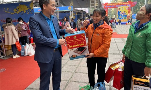 Phó Chủ tịch Liên đoàn Lao động Thành phố Hà Nội Lê Đình Hùng chúc mừng công nhân bốc thăm trúng thưởng và thăm hỏi về các mặt hàng công nhân đã mua ở "Chợ Tết Công đoàn". Ảnh: Linh Nguyên