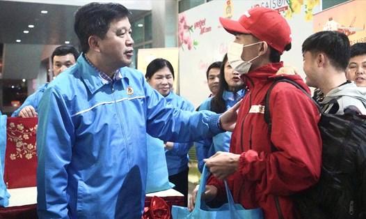 Ông Kha Văn Tám - Chủ tịch Liên đoàn Lao động tỉnh Nghệ An - trao quà cho công nhân lao động trở về từ miền Nam tại sân bay quốc tế Vinh. Ảnh: Quỳnh Trang