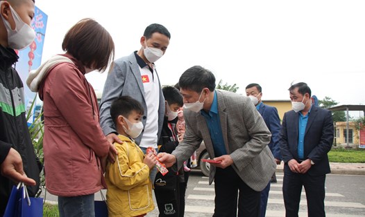 Ông Nguyễn Văn Cảnh - Chủ tịch Liên đoàn Lao động tỉnh Bắc Giang - trao lì xì cho con công nhân lao động trước khi gia đình họ lên chuyến xe do Công đoàn tổ chức đưa về quê ăn Tết Nhâm Dần 2022. Ảnh: NGUYỄN  HUYỀN